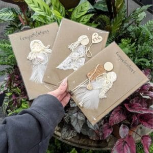 Three handmade congratulation cards featuring a woman holding a card with a bird design, showcasing heartfelt creativity.