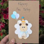 Cute handmade sheep birthday card with “Happy Baa-thday” text, featuring a sheep design holding balloons and wearing a party hat, decorated with a bow, perfect for kids and animal lovers.
