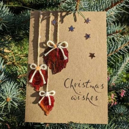 Best Eco-Friendly Christmas Card with dried leaves and bows hanging from a rope. Outside on Christmas Tree.