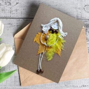 The best handmade birthday card for girlfriend. Is made of yellow feathers and fallen dry leaves on brown paper.