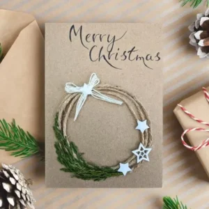 Best Handmade Merry Christmas Card with Wreath image 1 Handmade Merry Christmas card with twine and green festive wreath adorned with white star embellishments.