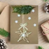 Handmade Rustic Christmas card with a yarn star, Christmas tree branch, and white stars.