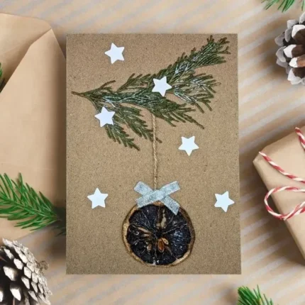 Handmade Personalised Christmas card features one dried orange slice, a branch, and stars.