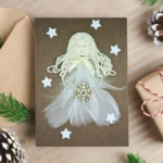 Handmade beautiful Angel Christmas card with white Angel made of feathers and snowflake.