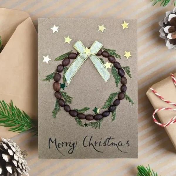 Handmade Wreath Christmas Card idea with bead wreath made of coffee beans, green foliage, and white bow.