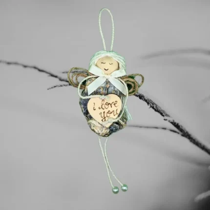 The image depicts a unique Shell Christmas ornament made from an oyster shell, featuring a heart that has the words 'I love you' written on it.