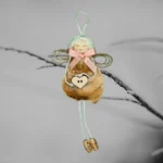 The image features a unique Shell Christmas Ornament adorned with a pink bow and a wooden heart, hanging from a branch.