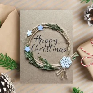 Handmade Happy Christmas Card - Spread Some Holiday Cheer image 1 Handmade Happy Christmas Card with a twine wreath, three stars, wooden snowflake and text Happy Christmas.