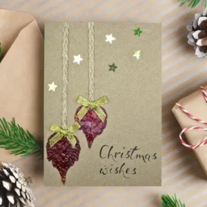 Handmade Heartwarming Christmas Card with Dried Leaves image 1 Handmade Heartwarming Christmas card adorned with dried leaves and stars, showcasing a handmade design.