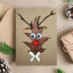 Hilarious Reindeer Christmas Card - handmade from leaves and a wooden stick, with a red nose reindeer design.