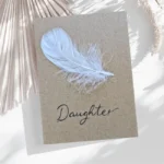 Simple handmade sympathy card made of white feather on brown paper.