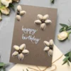 Unique Handmade Pistachio Shell Flower Birthday Card with 4 flowers made of pistachio shells with Happy Birthday text in the middle.