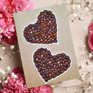 Unique Handmade Valentines Day Card. It showcases two hearts made of coffee beans on a brown, reusable paper card.