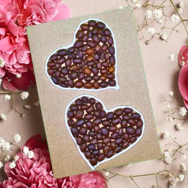 Unique Handmade Valentines Day Card. It showcases two hearts made of coffee beans on a brown, reusable paper card.