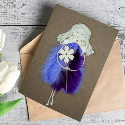 A unique Personalised Handmade Card for Women showcasing a girl in a purple dress with a flower, embellished with blue-violet feathers for a mystical touch.