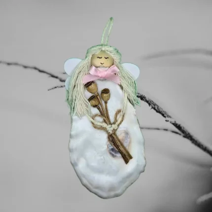 The image displays a unique white shell ornament made from oyster shells. She is holding a bouquet of dried flowers in her hand.