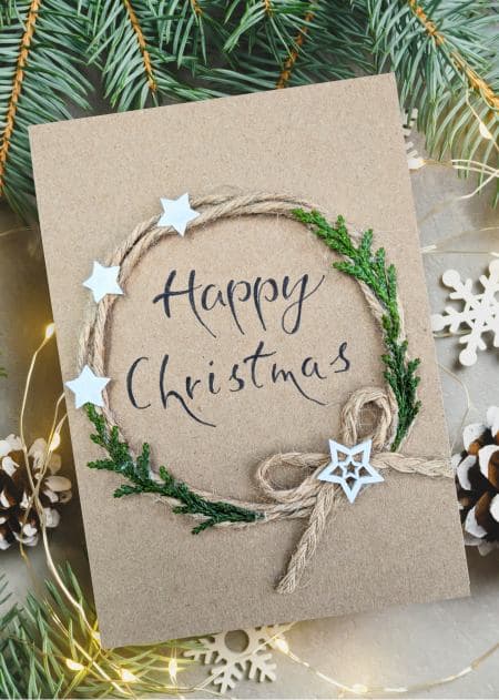 A handmade Christmas card showcasing a decorative wreath and stars, part of a collection banner for holiday cards.