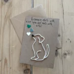 A handmade unique birthday card for dog lovers with a graphic depicting a dog on a string lying on a brown envelope.