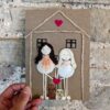 Personalised new home card with two figures made from seashells, twine, and a pink heart 3.