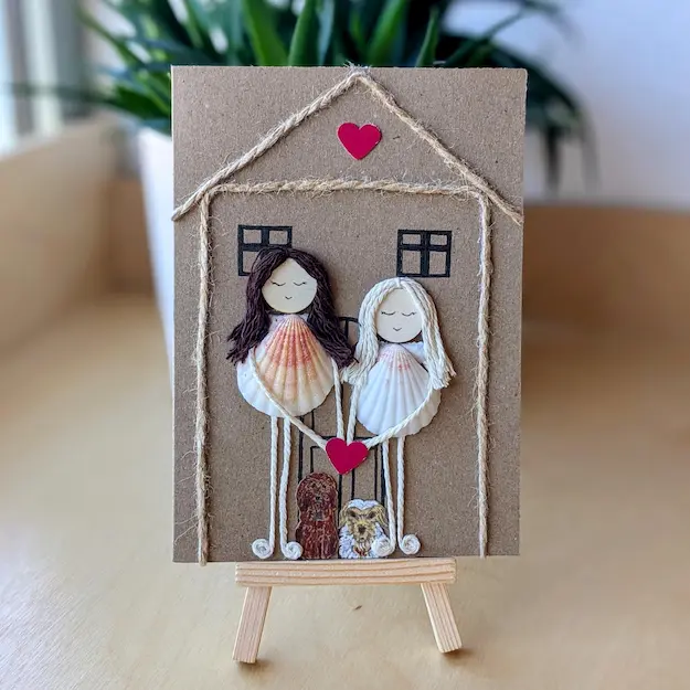 Personalised handmade new home card 1. Personalised new home card with two figures made from seashells, twine, and a pink heart 1.
