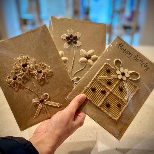 Three Bespoke handmade greeting cards inspired by nature featuring floral designs and decorative bows, showcasing unique craftsmanship and vibrant colours.