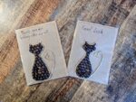Handmade cat greeting cards made with coffee beans and jute string on kraft paper, featuring ‘Thank you for looking after my cat’ and ‘Good Luck’ messages.