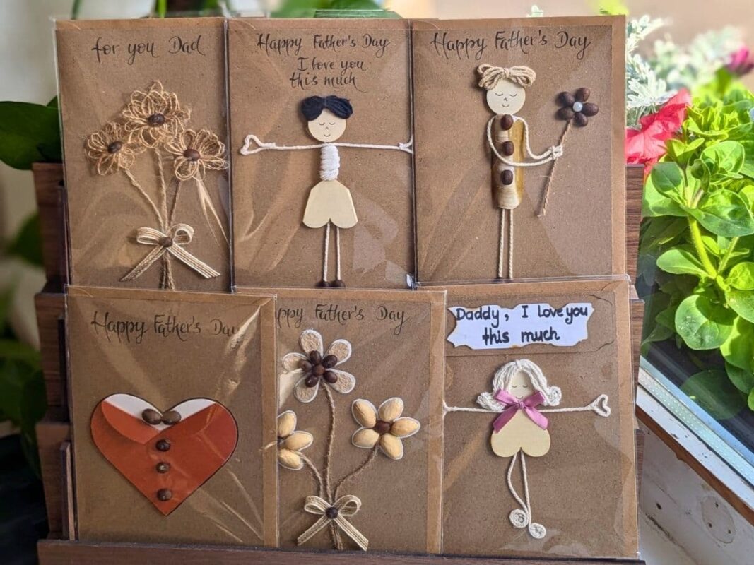 Six handmade Father’s Day cards on display featuring unique mixed-media designs made with coffee beans, twine, and shells, illustrating the meaningful connection and Gifting Psychology behind a personal touch.