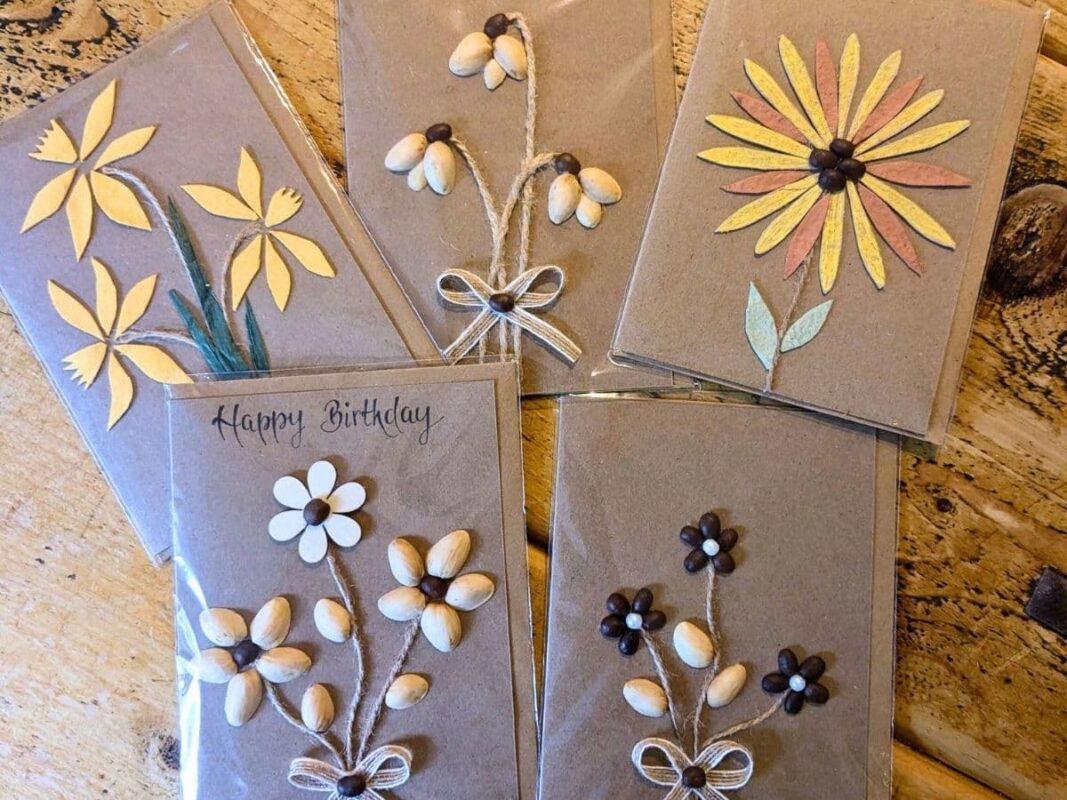 Five handmade birthday cards featuring 3D floral designs crafted from coffee beans, pistachio shells, and twine, illustrating the unique artisan charm and the Gifting Psychology behind meaningful, tactile keepsakes.