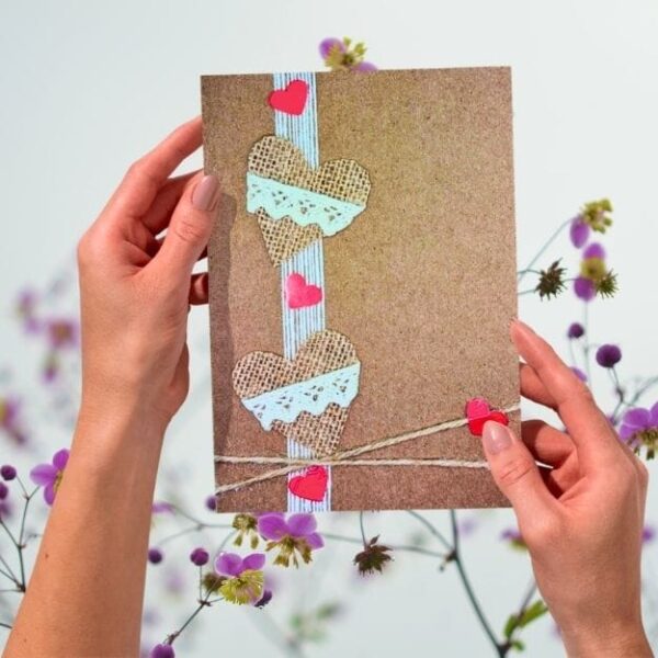 Handmade Valentines Day card featuring burlap hearts, lace trim, rustic kraft card background and twine bow, romantic eco-friendly design
