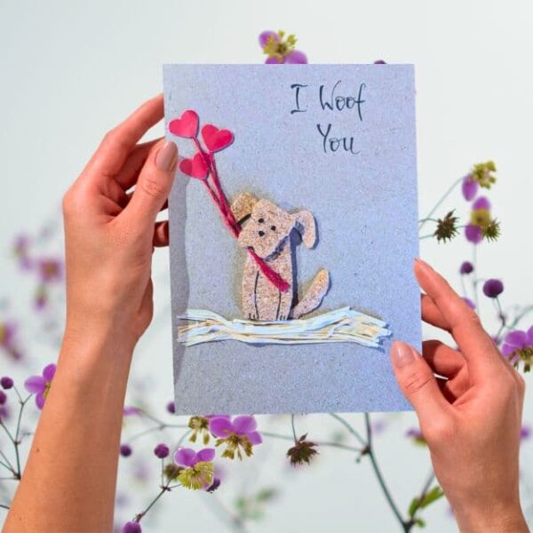 Handmade Dog Mum Valentines Card displayed with a rustic brown recycled envelope on a floral background.