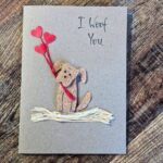 Handmade Dog Mum Valentines Card displayed with a rustic brown recycled envelope on a wooden background.