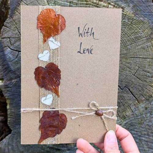 Types of greeting cards – handmade love card on kraft paper with dried leaves, twine bow and natural textures.