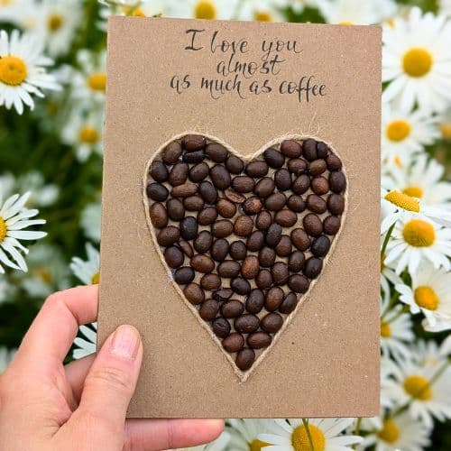 Types of greeting cards – handmade Valentine’s card with coffee bean heart on kraft paper.