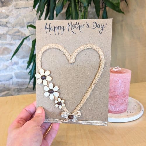 Types of greeting cards – handmade Mother’s Day card on kraft paper with heart design, floral details and natural textures.