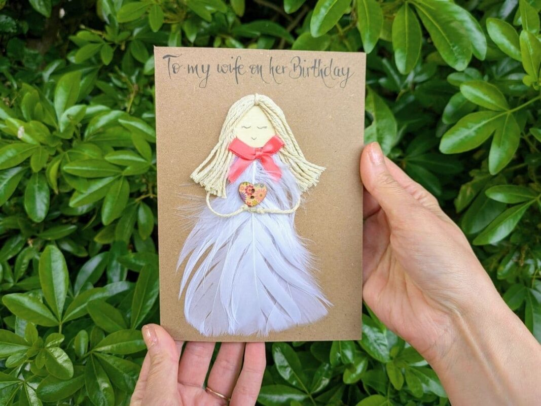 Handmade birthday card for wife featuring 3D feather dress and handmade calligraphy, illustrating the quality and cost of a handmade card.